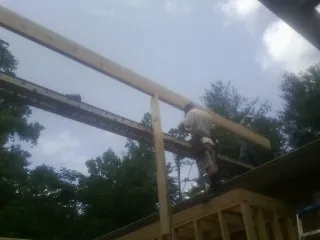 Carpenter setting a ridge beam over a new addition frame — Ice Dam Removal by Roofing Brothers in Ridley Park