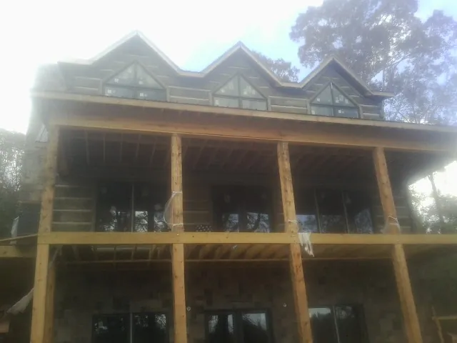 Dormers and porch framing on a large log home under construction — Roof Coating work by our crew in Ridley Park