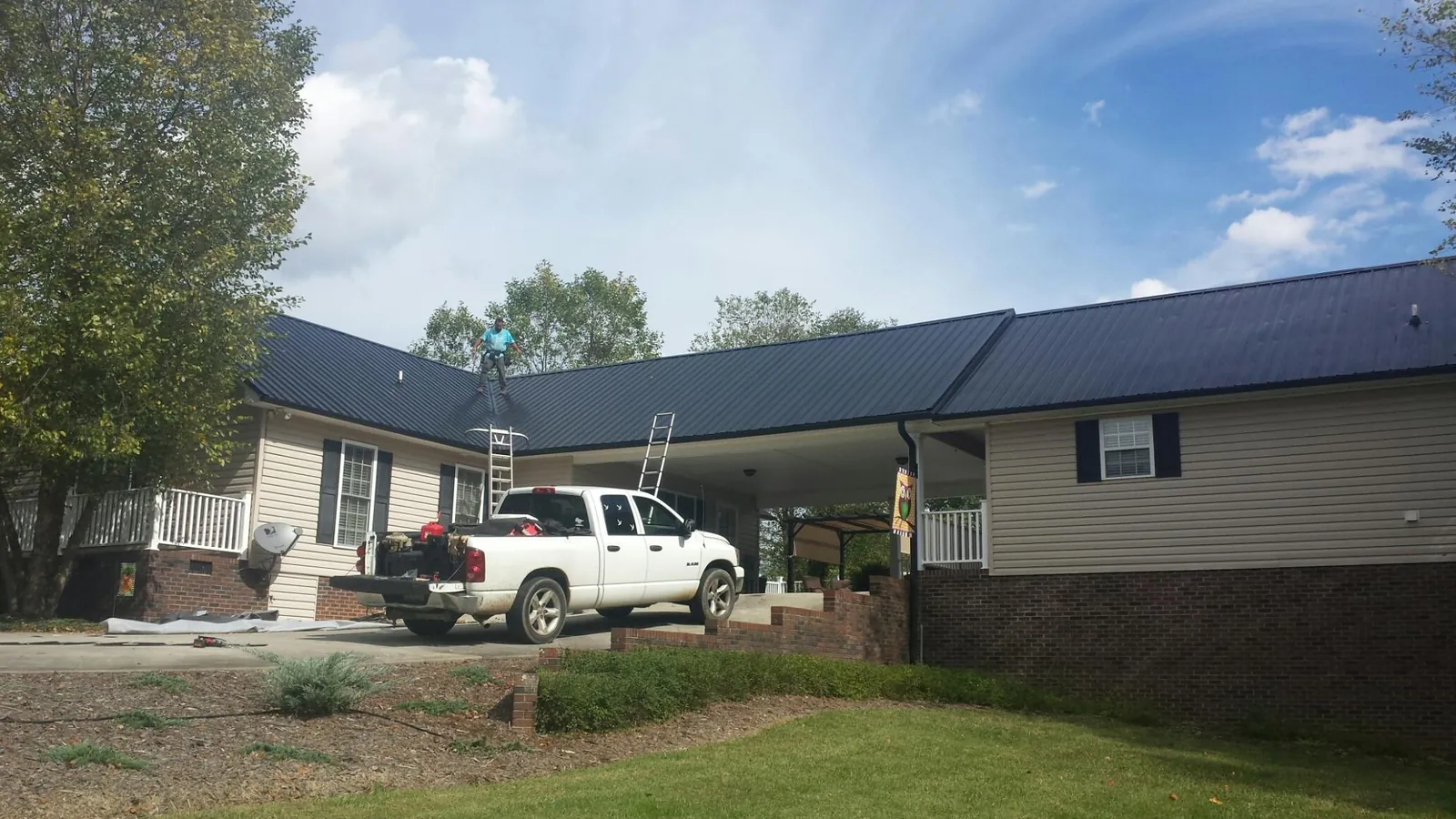 Black metal roof over a home and attached breezeway with ladders set in Ridley Park